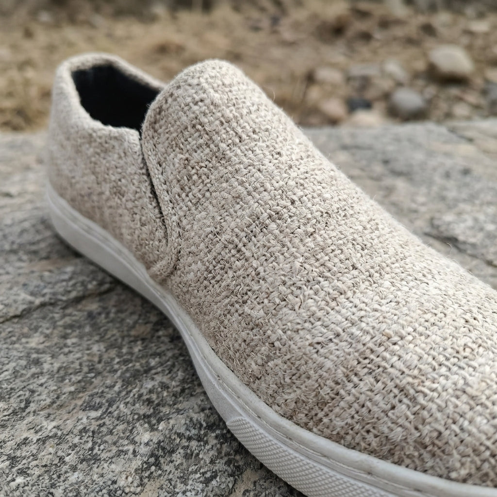 Beige  pure hemp slip-on shoe with white  bio degradable rubber sole on a stone surface