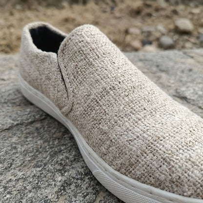 Beige  pure hemp slip-on shoe with white  bio degradable rubber sole on a stone surface