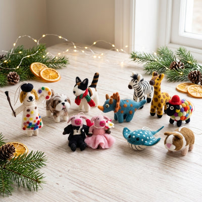 Collection of small animal Felted ornaments on a wooden surface with decorative elements.