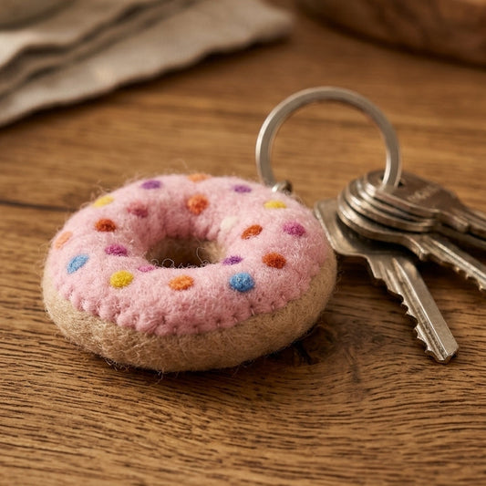 Felt Donut Keychain – Pink Sprinkle Wool Key Ring, Handmade in Nepal  on a wooden surface.