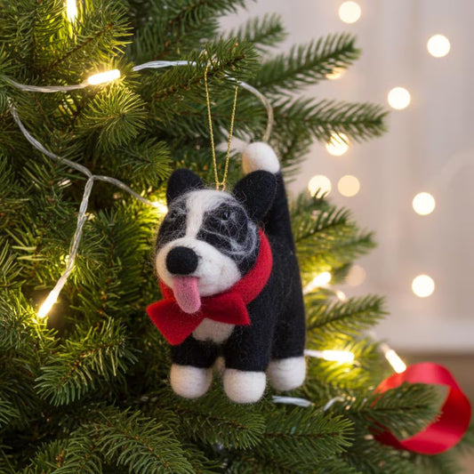 Handmade wool felt Border Collie dog ornament with black and white markings Christmas ornament on a decorated tree with lights in the background