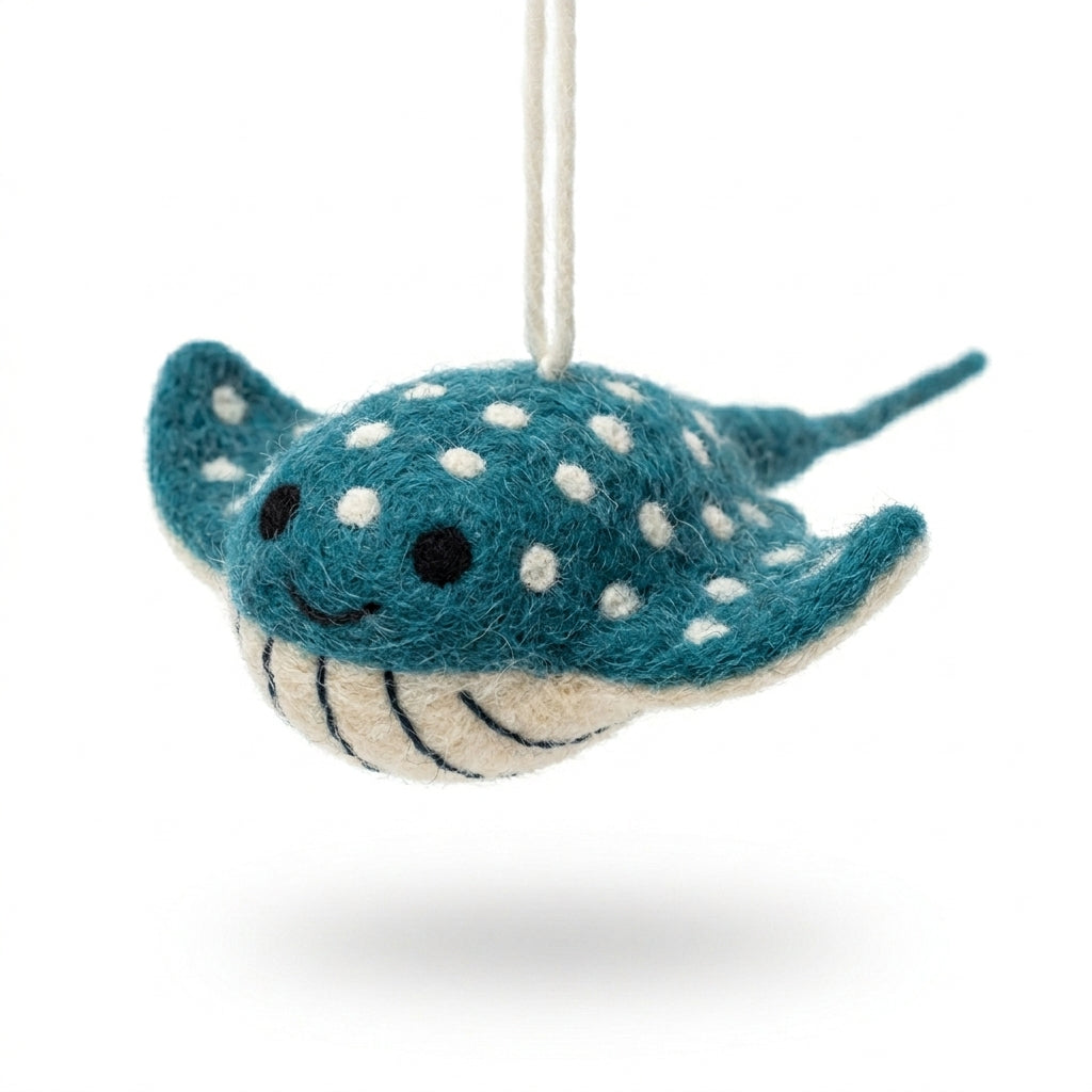 Felted shark ornament with white polka dots on a white background