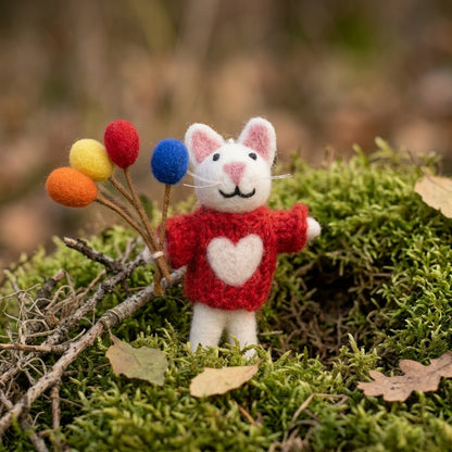 Handmade wool felt mouse with balloons ornament red sweater with a heart on it, standing on green moss with colorful balloons.
