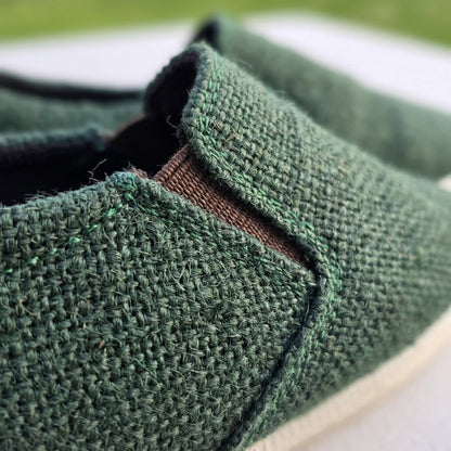 Close-up of natural rubber sole hemp shoes handmade sustainable footwear with a blurred outdoor background.