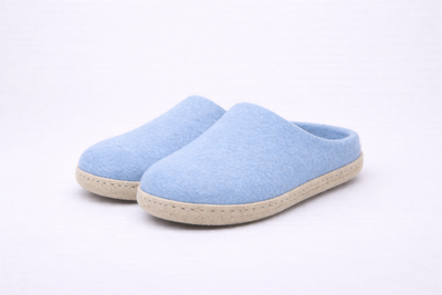 Pair of light blue slippers on a white background