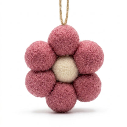 Pink felt flower ornament with a white center on a white background