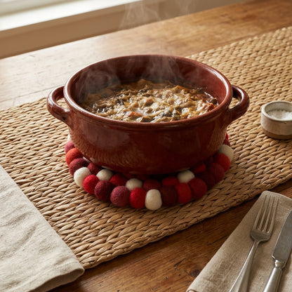 Ceramic bowl with a hot beverage on a wooden table with a woven mat