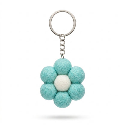 Small blue felt flower keychain with metal keyring on a white background