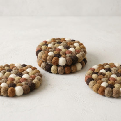 Set of three round, multicolored coasters on a light surface