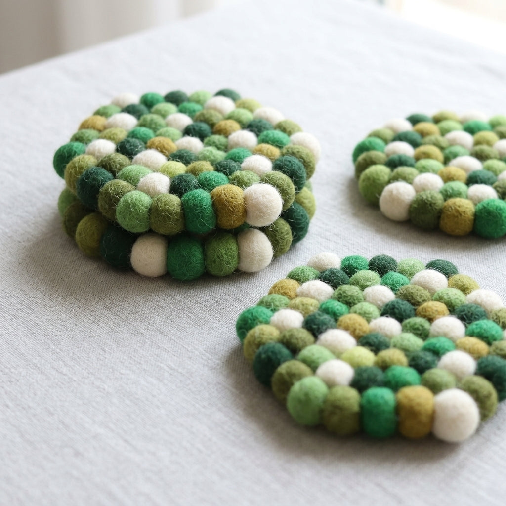 Set of Forest Mix Green wool felt coasters handmade in Nepal, botanical absorbent non-scratch drink coasters for wooden tables, plant lover gifts, host gifts and new home buyers on a light surface