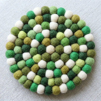 RoundForest Mix Green wool felt coasters handmade in Nepal, botanical absorbent non-scratch drink coasters for wooden tables, plant lover gifts, host gifts and new home buyers on a light gray background