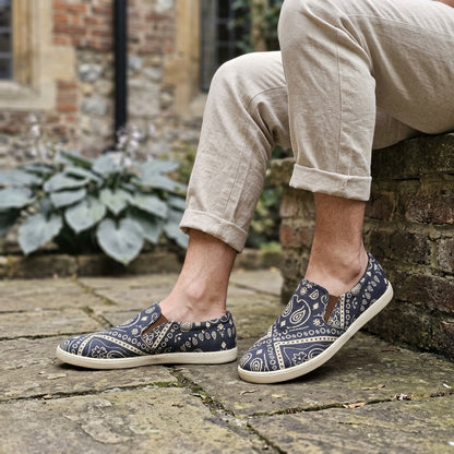 Person wearing mandala patterned  biodegradable hemp shoes on a stone surface with a garden background