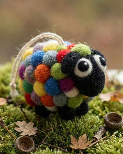 Handmade wool felt pig couple ornament with hanging thread on a grassy background