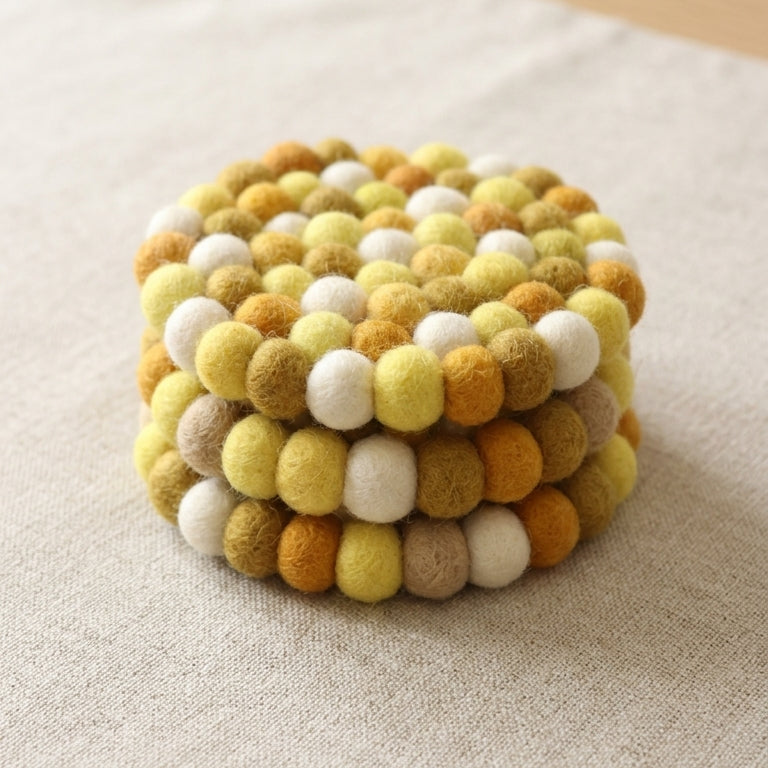 Mustard Yellow wool felt coasters handmade in Nepal, warm absorbent non-scratch drink coasters for wooden tables, teacher gifts, host gifts and new home buyers on a textured surface