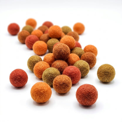 orange felt balls for crafts and kids diy projects on a white background