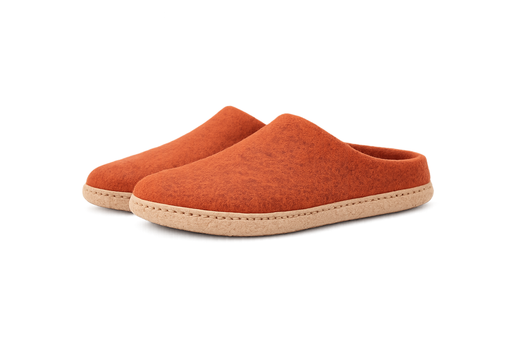 Pair of orange slippers on a white background