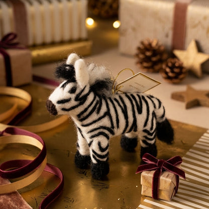  Handmade wool felt zebra ornament on a table with Christmas decorations and presents