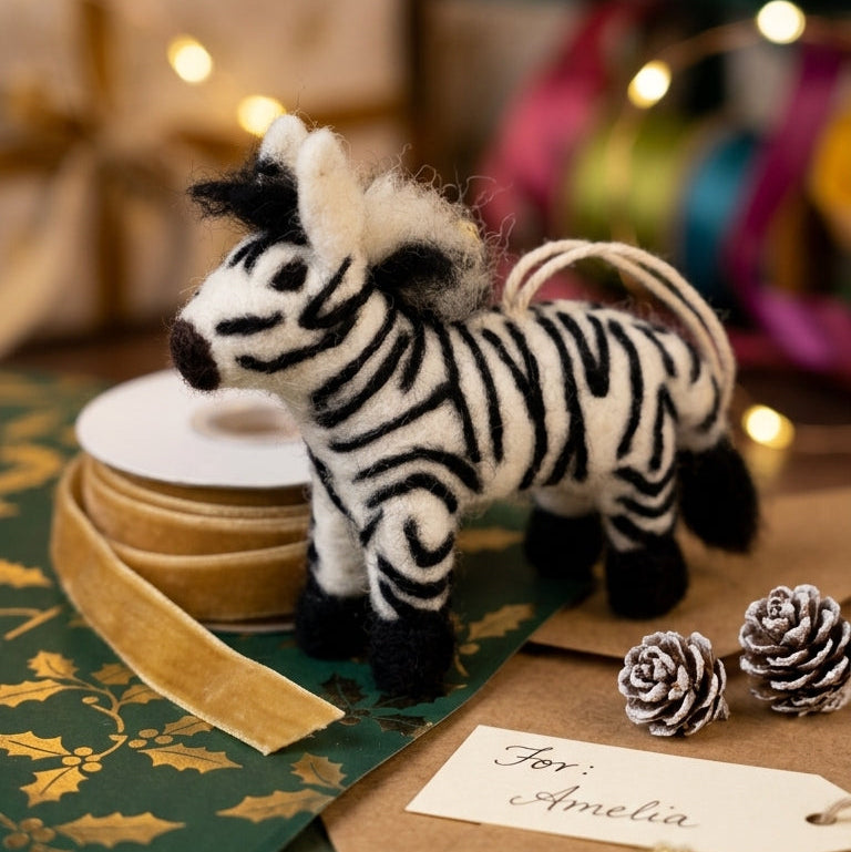 Handmade wool felt zebra ornament on a decorative table with lights in the background